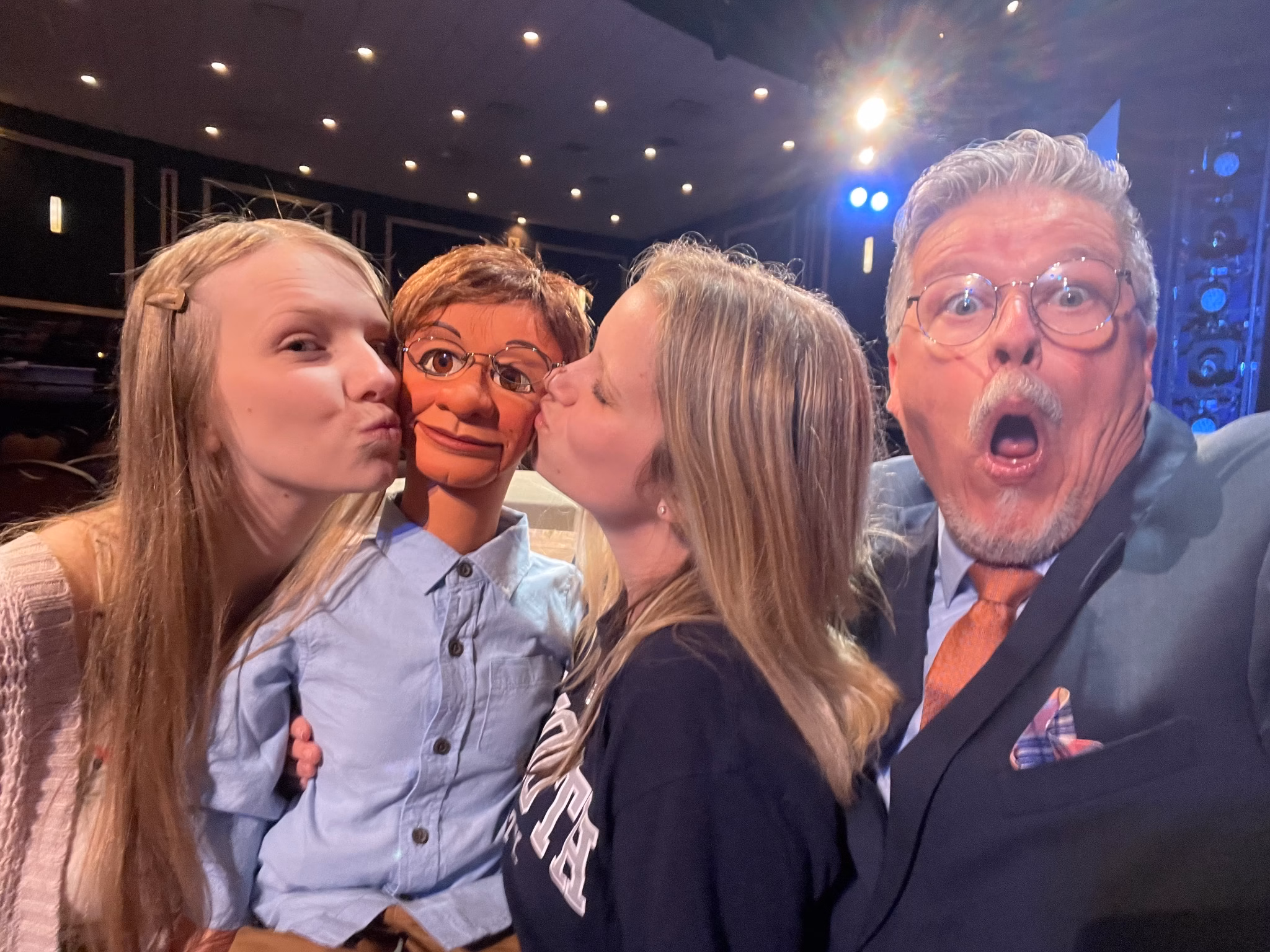 Two audience members kiss Paul Donnelly while Al Getler reacts.
